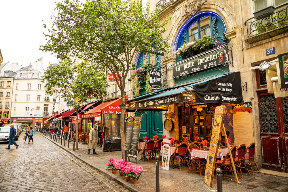 Paris, France - 24.04.2019: Latin Quarter. Narrow street of Paris among old traditional parisian houses and cafe in Paris in France